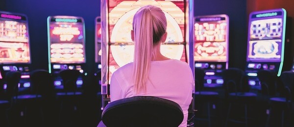 Žena v casinu se baví hrou na automatu