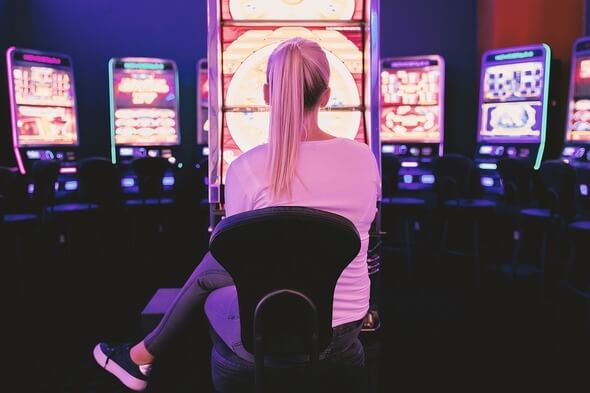 Žena v casinu se baví hrou na automatu